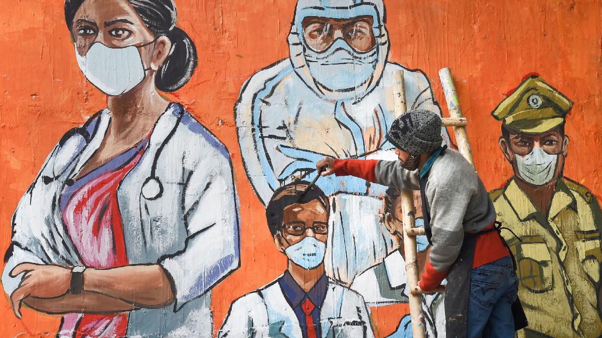 दिल्ली में वीकेंड कर्फ्यू के दौरान कोरोना वॉरियर्स की तस्वीर बनाता आर्टिस्ट (फोटो - पीटीआई)