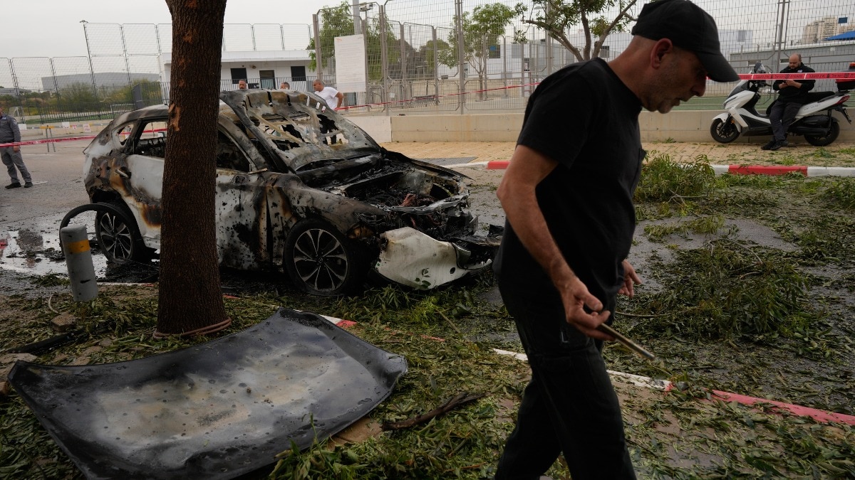 A man inspects the site of an Iranian missile strike in Petah Tikva, Israel,