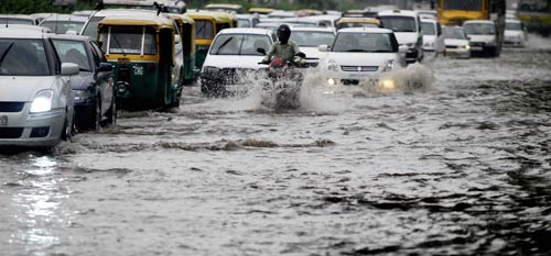 दिल्‍ली में भारी बारिश, तालाब में तब्‍दील हुई सड़कें | पढ़ें