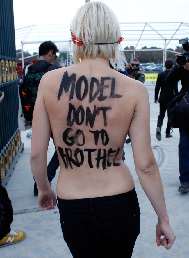 पेरिस फैशन शो में घुसी टॉपलेस महिला प्रदर्शनकारी