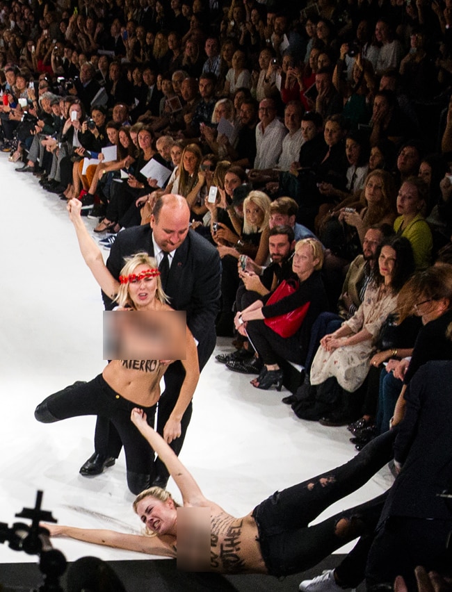 पेरिस फैशन शो में घुसी टॉपलेस महिला प्रदर्शनकारी