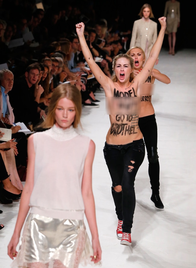 पेरिस फैशन शो में घुसी टॉपलेस महिला प्रदर्शनकारी