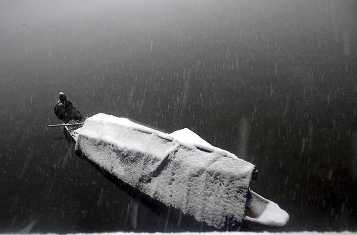 डल झील पर जमी बर्फ की चादर, तस्‍वीरों में देखें जन्‍नत के नजारे