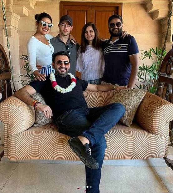 कौन है ये शख्स जिसके पीछे निक संग खड़ी हैं प्रियंका चोपड़ा?