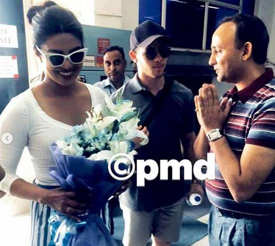 कौन है ये शख्स जिसके पीछे निक संग खड़ी हैं प्रियंका चोपड़ा?