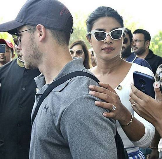 कौन है ये शख्स जिसके पीछे निक संग खड़ी हैं प्रियंका चोपड़ा?