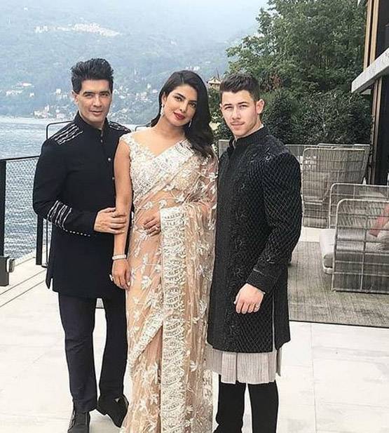 कौन है ये शख्स जिसके पीछे निक संग खड़ी हैं प्रियंका चोपड़ा?