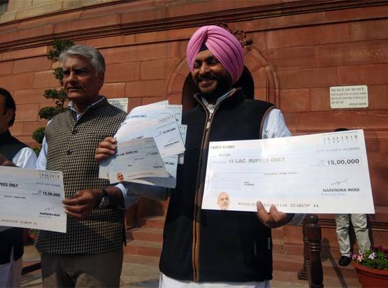 आ गया, आ गया 15 लाख का चेक! संसद के बाहर लोगों के हाथों में दिखा