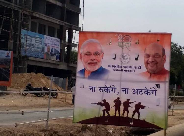 अहमदाबाद: रैली से पहले बंदूक के साथ लगे पीएम मोदी के पोस्टर