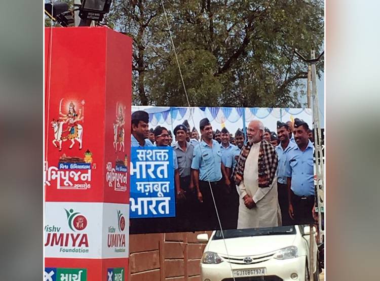 अहमदाबाद: रैली से पहले बंदूक के साथ लगे पीएम मोदी के पोस्टर