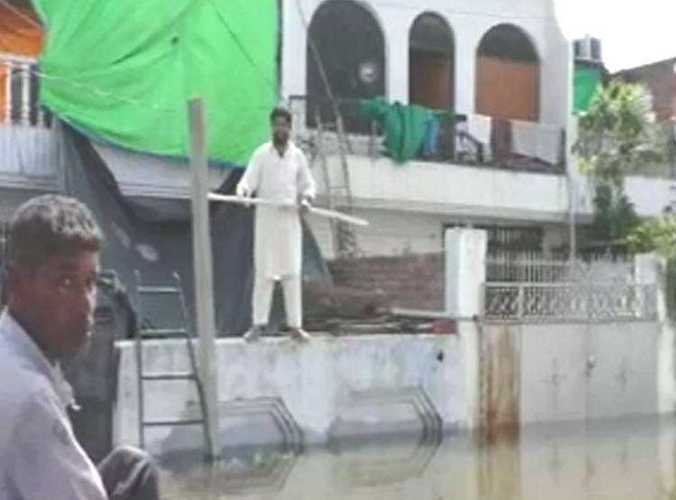 साड़ी में स्वीम‍िंग करने लगी मह‍िला, घर में घुसा था बाढ़ का पानी