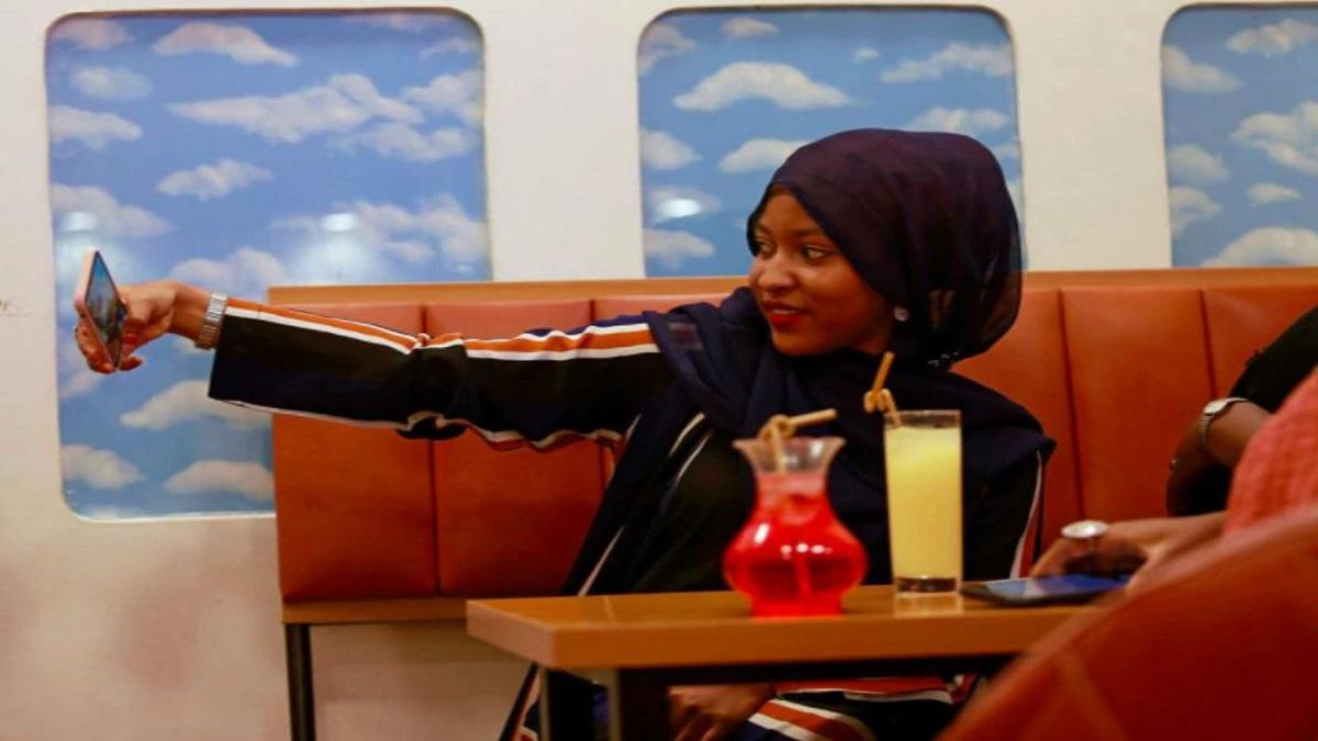 रेस्टोरेंट में सेल्फी लेती महिला