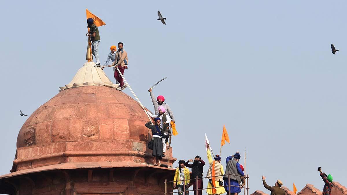 लाल किले पर अपना झंडा लहराते प्रदर्शनकारी फोटो-एपी