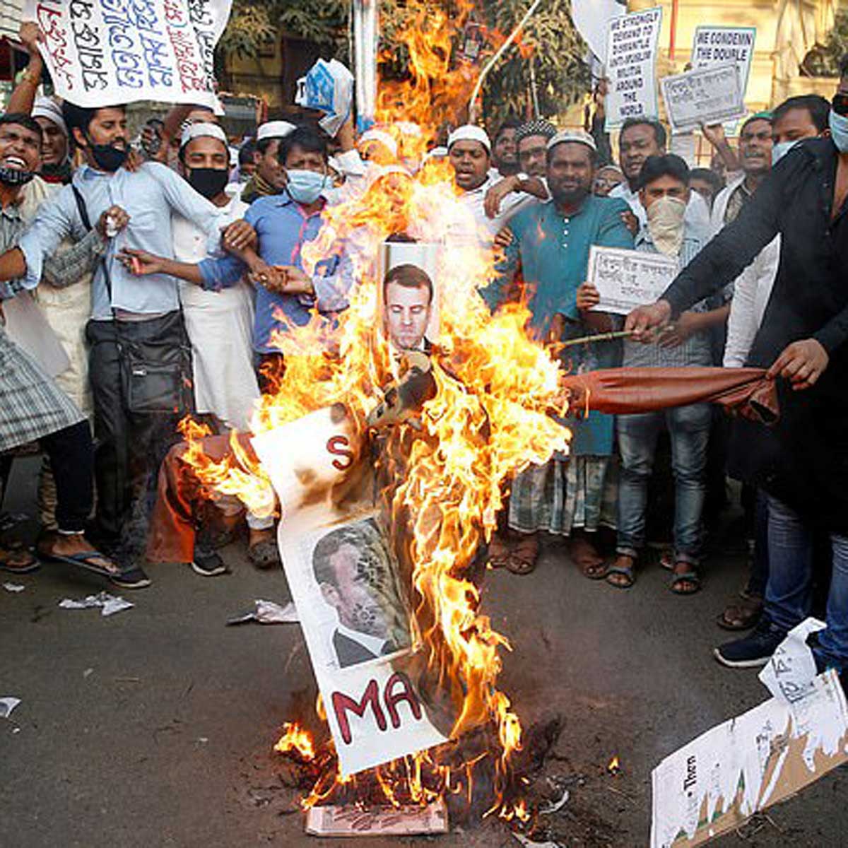 फ्रांस के राष्ट्रपति के पुतले जलाते लोग