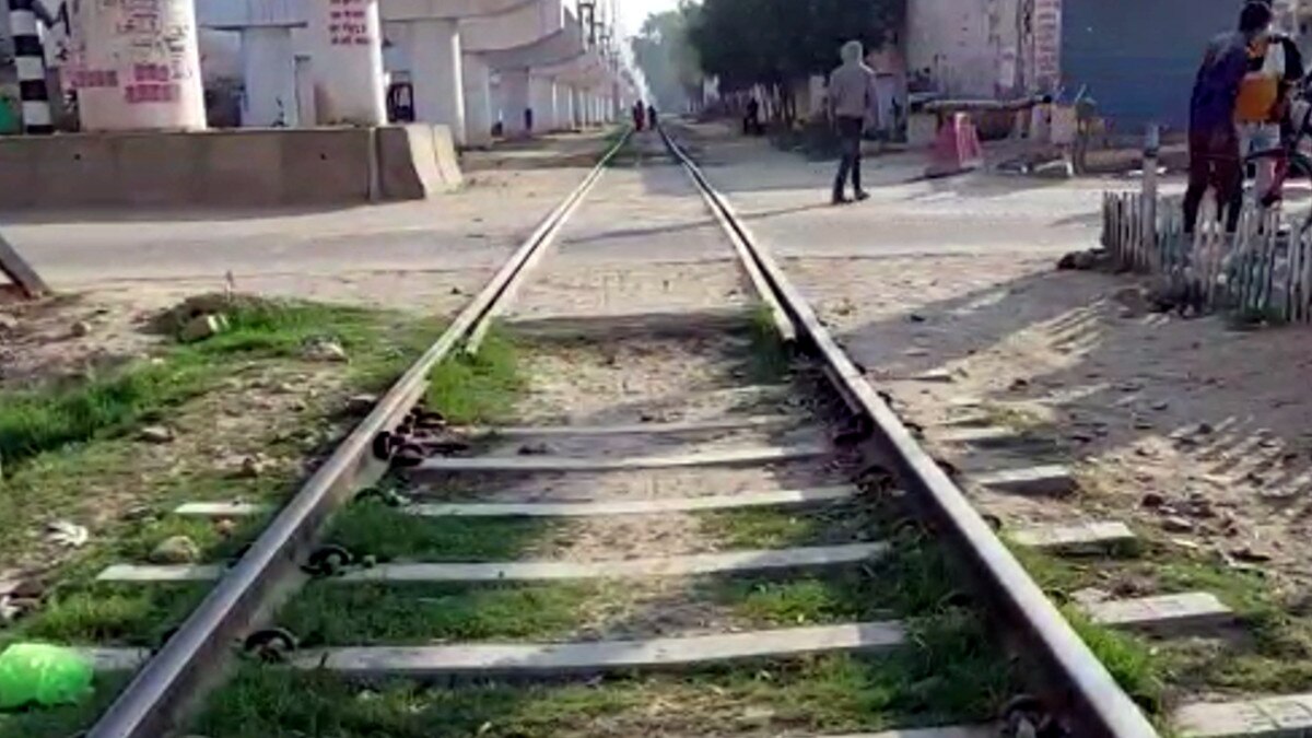 फाटक पर खड़ी मालगाड़ी के नीचे से निकल रही थी महिला, अचानक चली ट्रेन, वायरल हुआ वीड‍ियो 