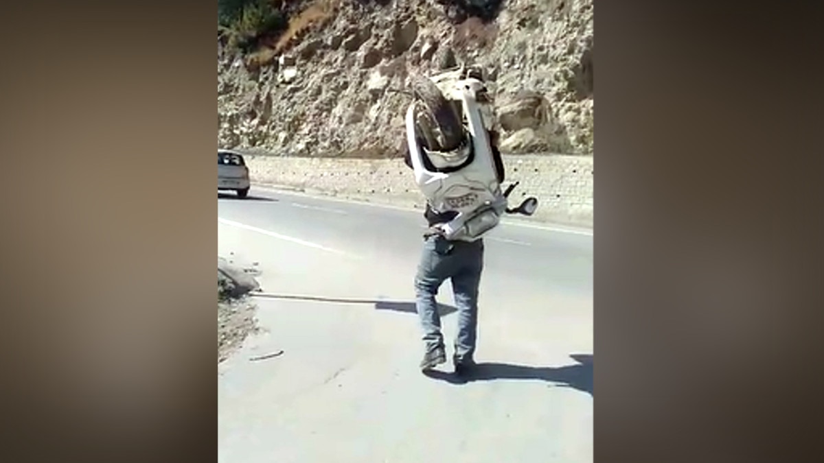 कंधे पर स्कूटी लेकर सड़क पर निकला शख्स, सोशल मीड‍िया पर वायरल हुआ वीड‍ियो 