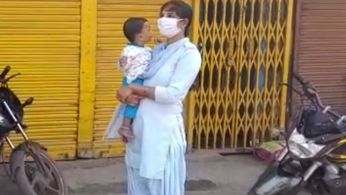 कोरोना कर्फ्यू के दौरान मासूम बच्चे को गोद में लेकर ड्यूटी कर रही है महिला पुलिसकर्मी 