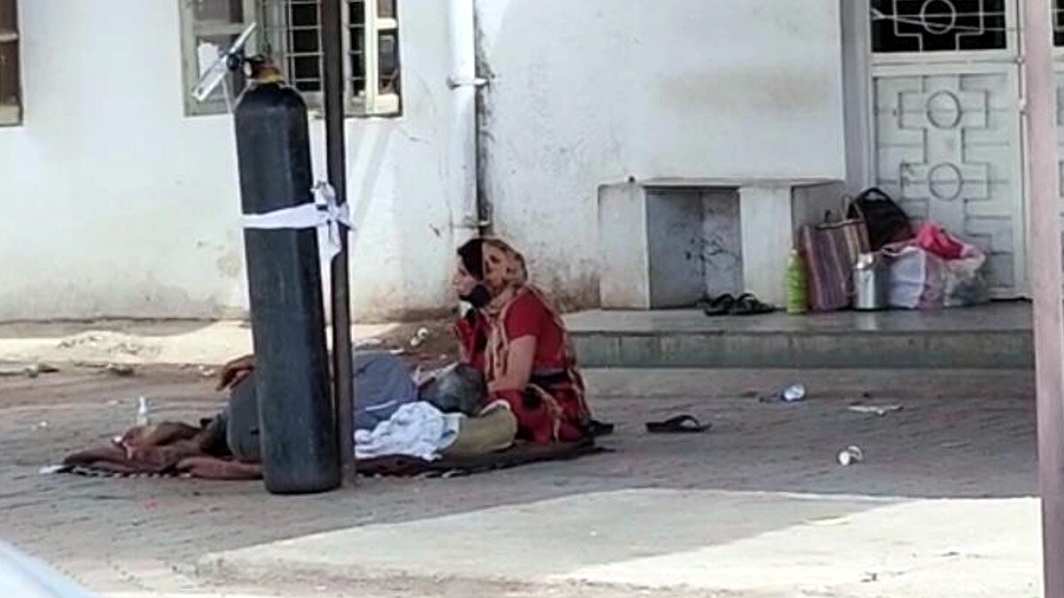 जमीन पर 18 घंटे लेटा रहा बुज़ुर्ग मरीज़, खंभे से बंधा था ऑक्सीजन सिलेंडर जमीन पर 18 घंटे लेटा रहा बुज़ुर्ग मरीज़, खंभे से बंधा था ऑक्सीजन सिलेंडर