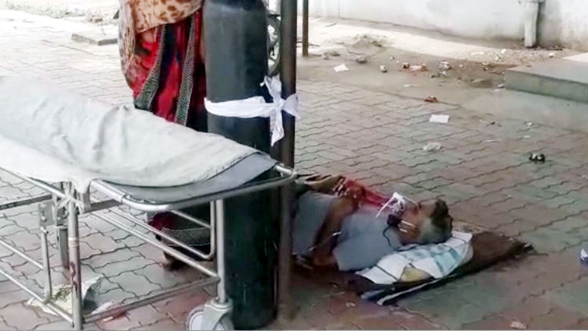 जमीन पर 18 घंटे लेटा रहा बुज़ुर्ग मरीज़, खंभे से बंधा था ऑक्सीजन सिलेंडर जमीन पर 18 घंटे लेटा रहा बुज़ुर्ग मरीज़, खंभे से बंधा था ऑक्सीजन सिलेंडर