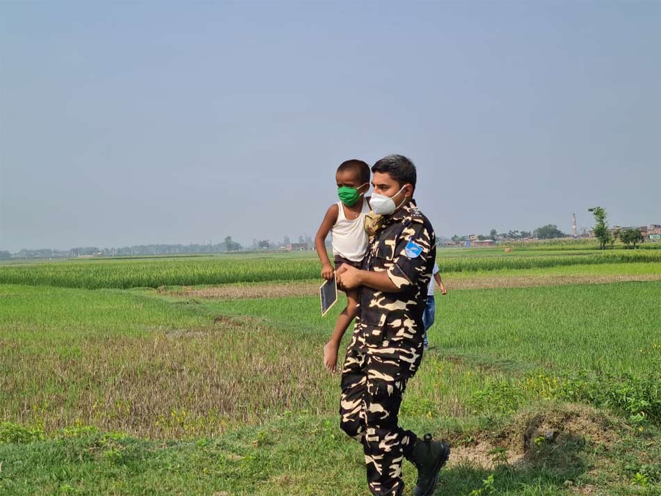 बच्चे को गोद में ल‍िए सीमा पर तैनात जवान (Photo: aajtak.in)   