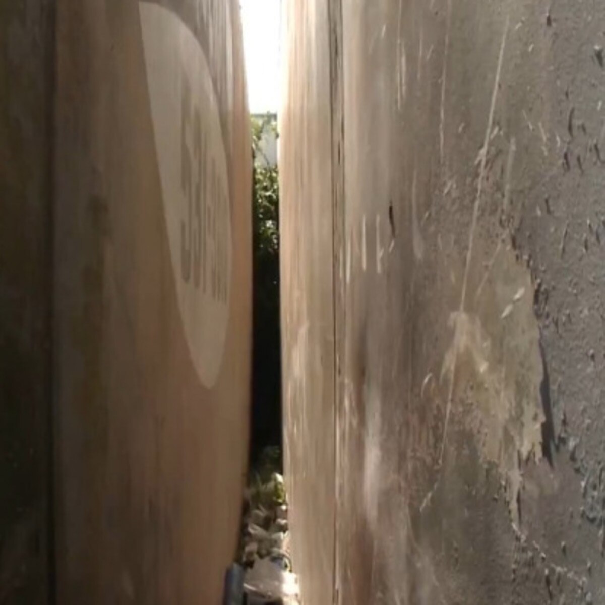 naked woman stuck between two buildings