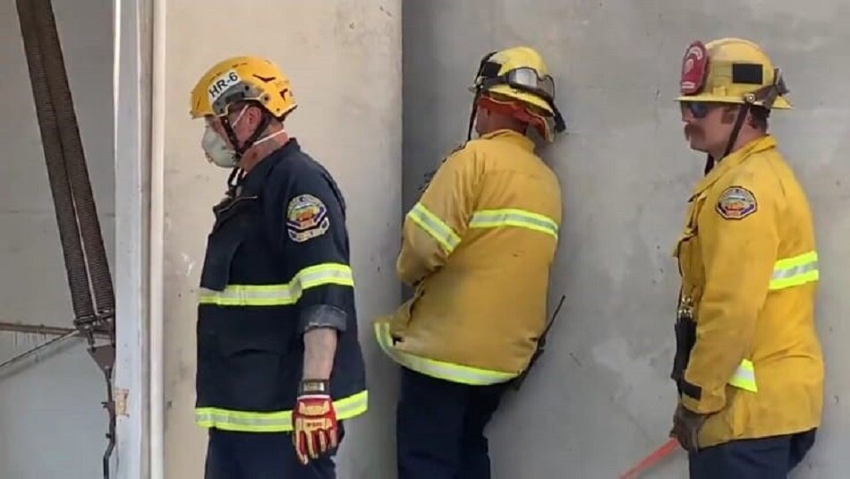 naked woman stuck between two buildings