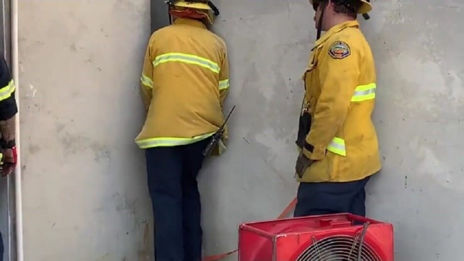 naked woman stuck between two buildings