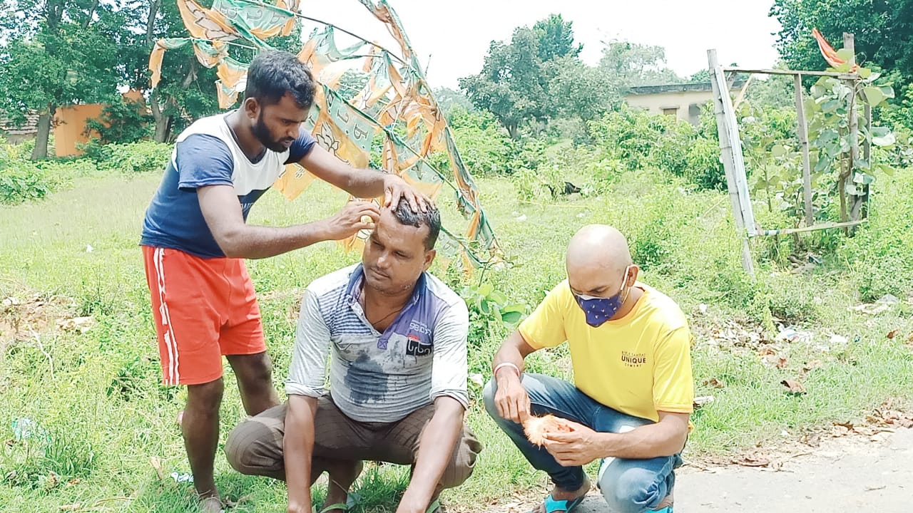 सिर मुंडवाते लोग