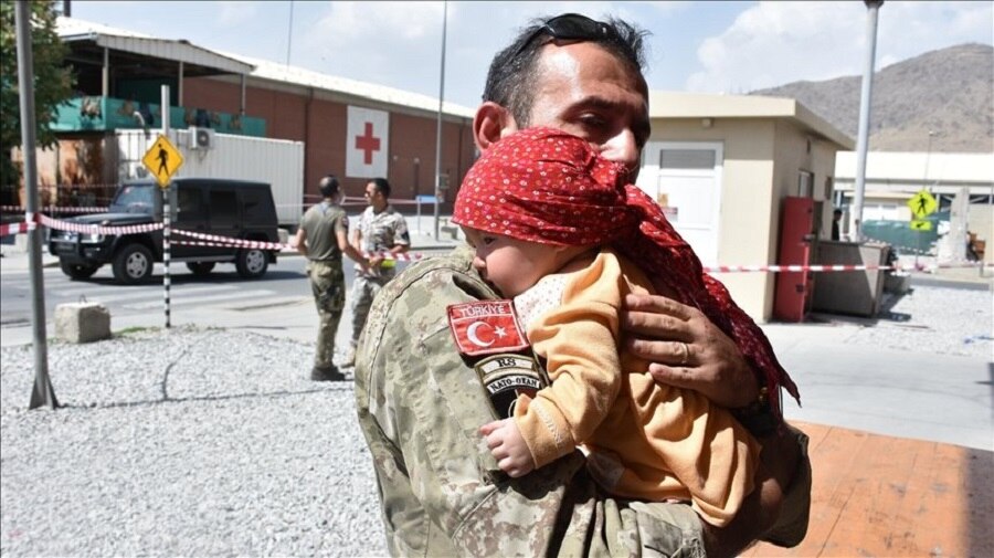 soldiers helping Afghan baby 