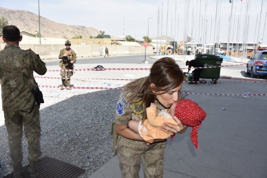soldiers helping Afghan baby 
