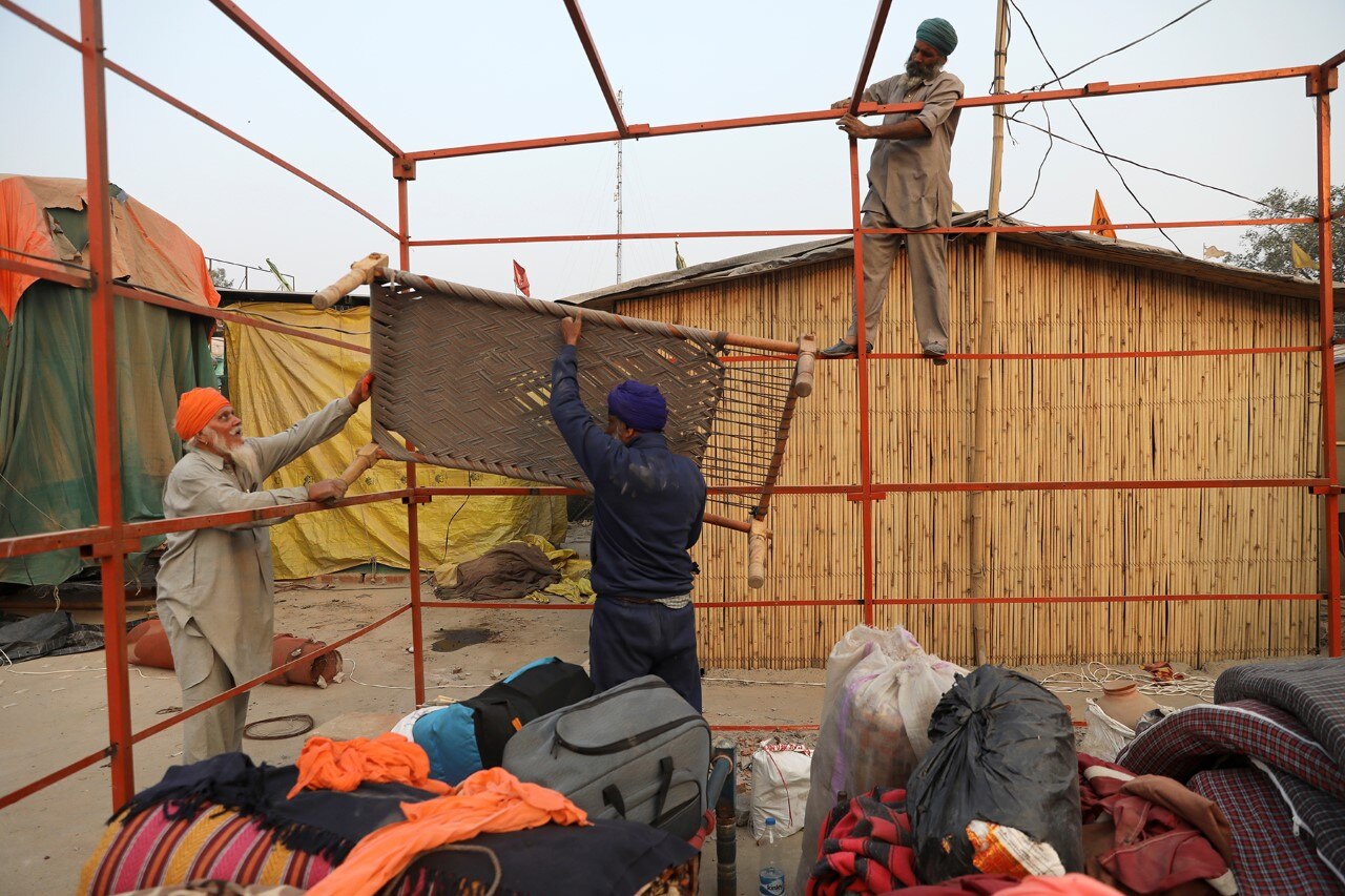 सिंघु बॉर्डर में अपना सामान समेटते किसान