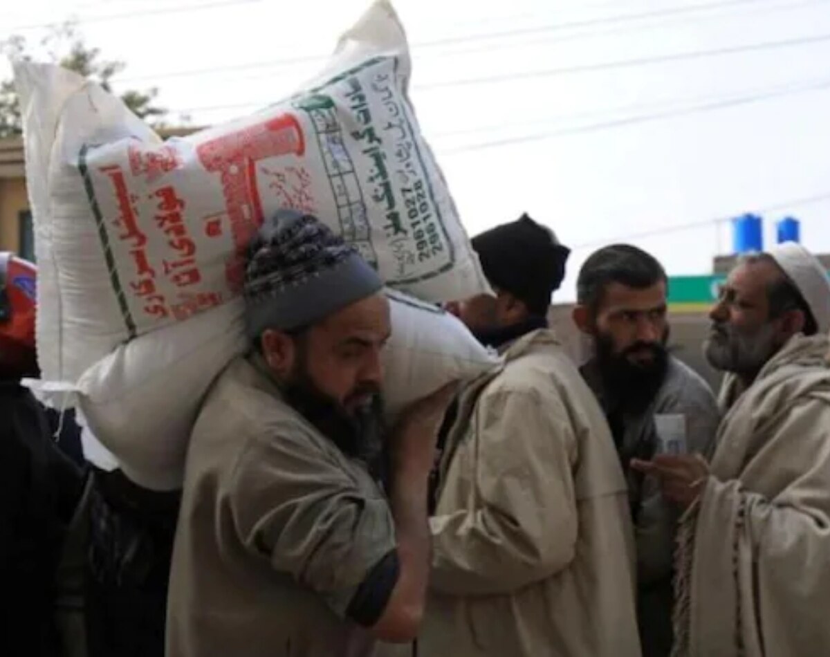 कंधे पर बोरिया लादे दिख रहे लोग