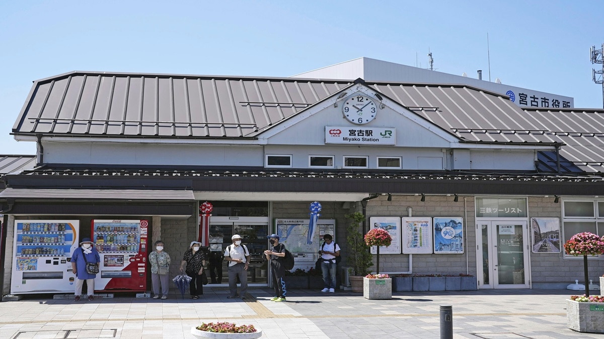 Passengers stand in front of a staion in Miyako, Iwate prefecture, northern Japan as train services were suspended due to a tsunami alert (Photo-Kyodo News via AP)