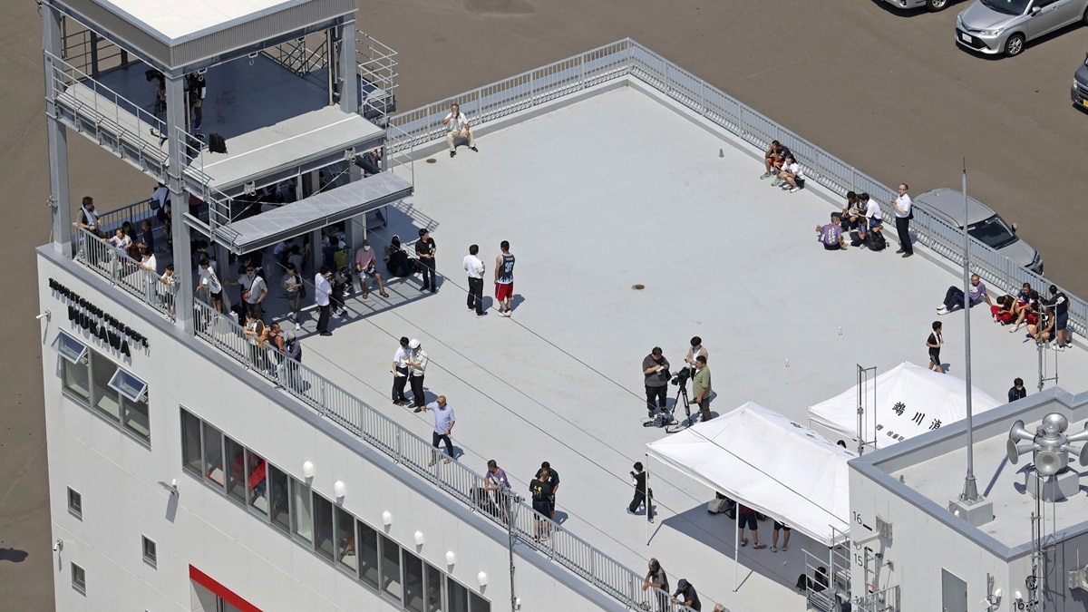 People take shelter on the roof of a fire station in Mukawa town, Hokkaido, northern Japan (Photo-Kyodo News via AP)