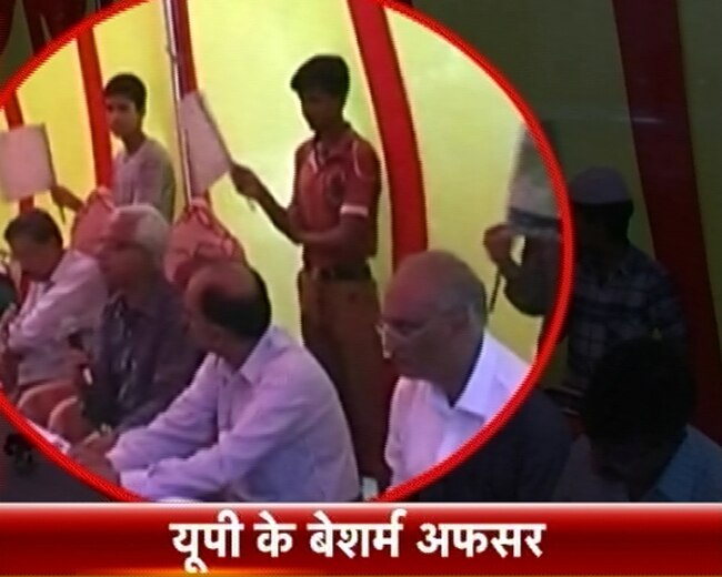 बच्‍चों से पंखा झलवाते अधिकारी