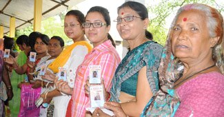 असमः पोलिंग बूथ पर मतदान का इंतजार करती महिलाएं