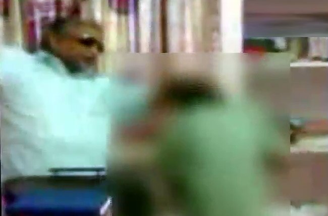 बच्‍चों की पिटाई के वीडियो फुटेज से ली गई तस्‍वीर