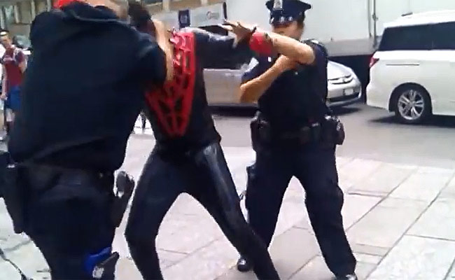 जूनियर बिशप नामक व्यक्ति ने स्पाइडरमैन का ड्रेस पहन पुलिसवाले को घूंसा जड़ा