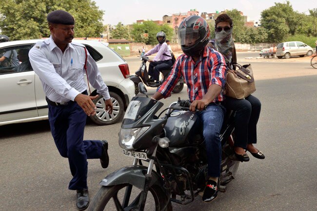 बिना हेलमेट महिला चालकों को चालान काटती पुलिस