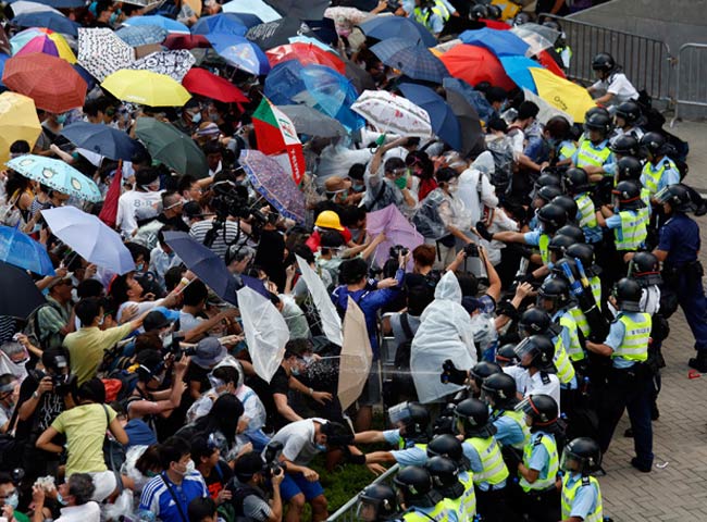 हांगकांग में प्रदर्शनकारियों को रोकती पुलिस