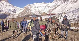 तूफान में घायल व्यक्ति को ले जाते नेपाल सैनिक