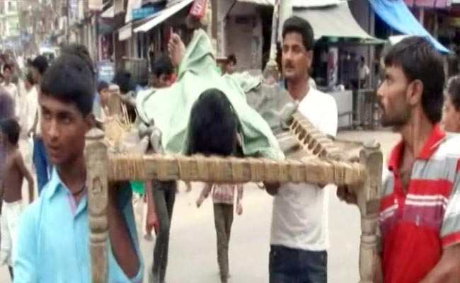 मृतक युवक का शव ले जाते लोग