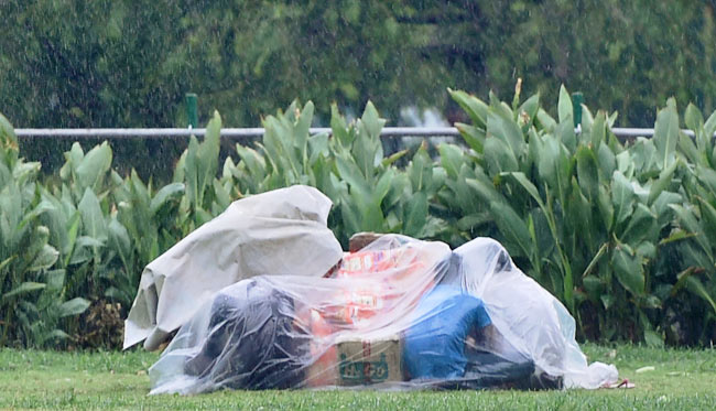 बारिश से बचाव करते लोग