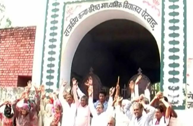 गेस्‍ट टीचर्स को हटाए जाने का विरोध करते लोग