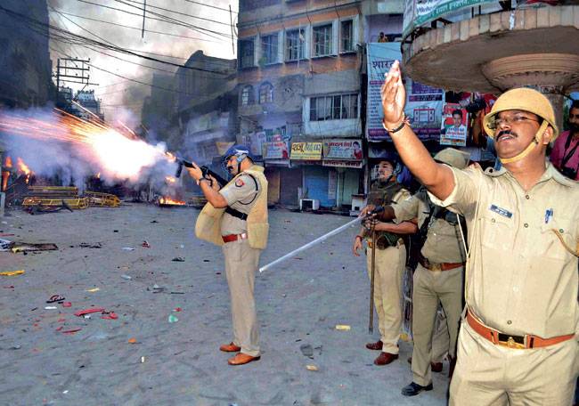 वाराणसी में उपद्रव को काबू में करने के लिए सख्ती करती पुलिस