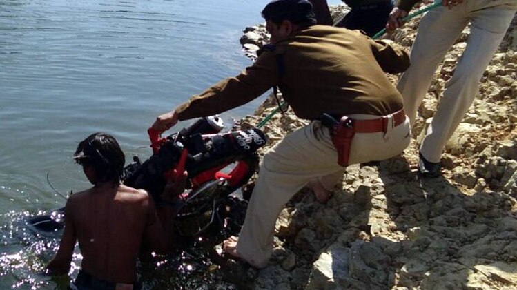 तालाब से बाइक निकालते पुलिसकर्मी