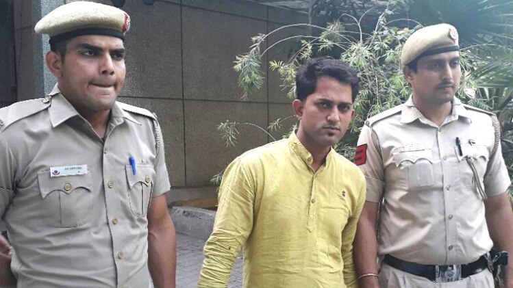 पुलिस गिरफ्त में खड़ा आरोपी पूरन गुप्ता
