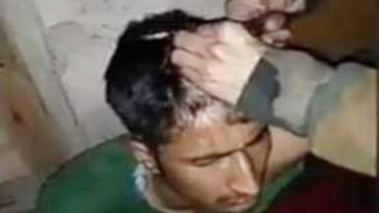 ग्राम रक्षा दल के सदस्य के बाल उतारते आतंकी