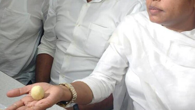 चावल दिखाती महिला