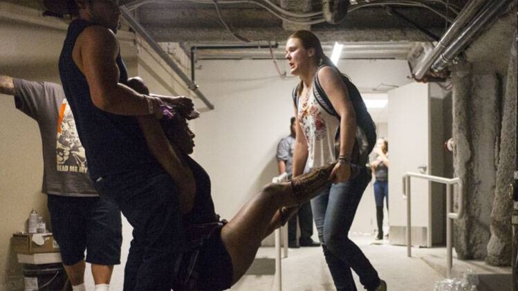 गोलीबारी में घायल को ले जाते लोग